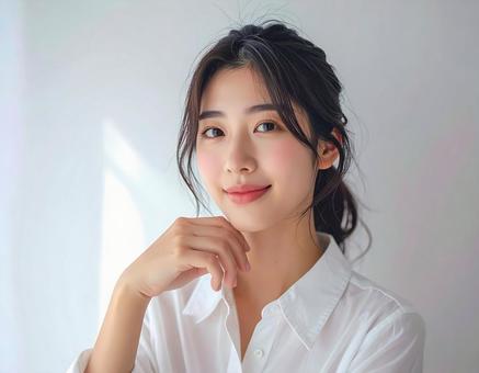 笑顔で頬杖をつく若い女性の写真