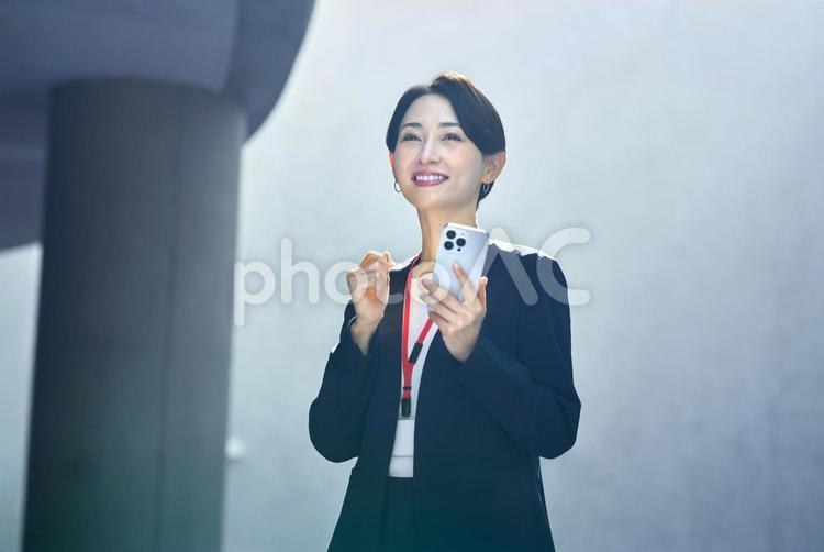 スマホを持ちガッツポーズする女性　仕事 ガッツポーズ,スマートフォン,ガッツの写真素材