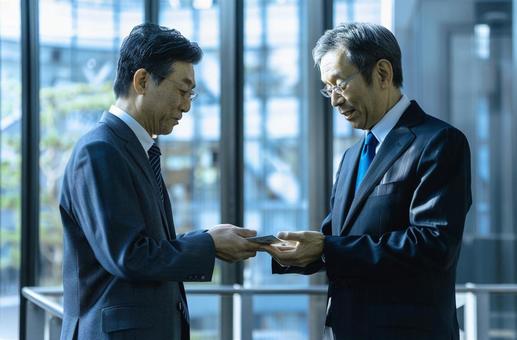 名刺交換するビジネスマンの写真