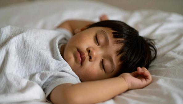 両手をあげて熟睡する男の子 両手をあげて熟睡する男の子の写真