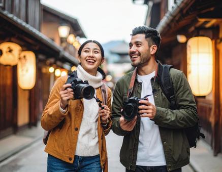 カメラを持って旅する若いカップル カメラを持って旅する若いカップルの写真