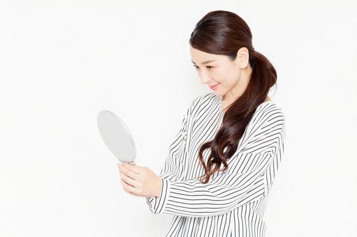 Casually dressed female holding a hand mirror, handspiegel, fem, zu sehen, JPG