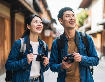 カメラを持って旅する若いカップル カメラを持って旅する若いカップルの写真