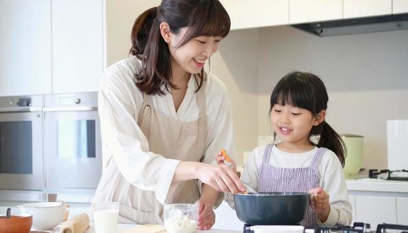 笑顔で料理をする母娘 笑顔で料理をする母娘の写真