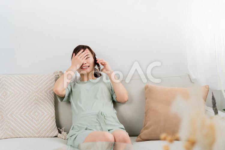 陣痛がきて電話するアジア人女性（妊婦） 陣痛,流産,破水の写真素材