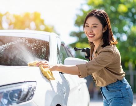 手洗い洗車中の女性 手洗い洗車中の女性の写真