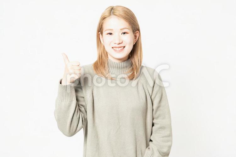 いいねのポーズをするセーターを着た若い女性 いいね,親指,女性の写真素材