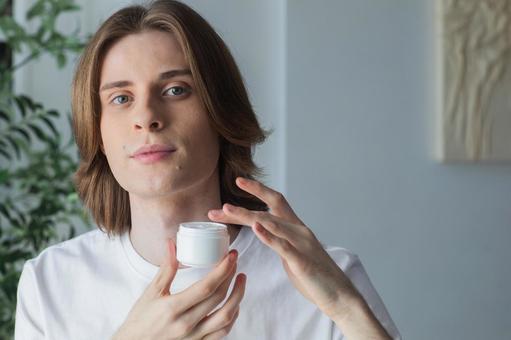 保湿クリームを指に取るカメラ目線の男性 男性,外国人,欧米人の写真素材