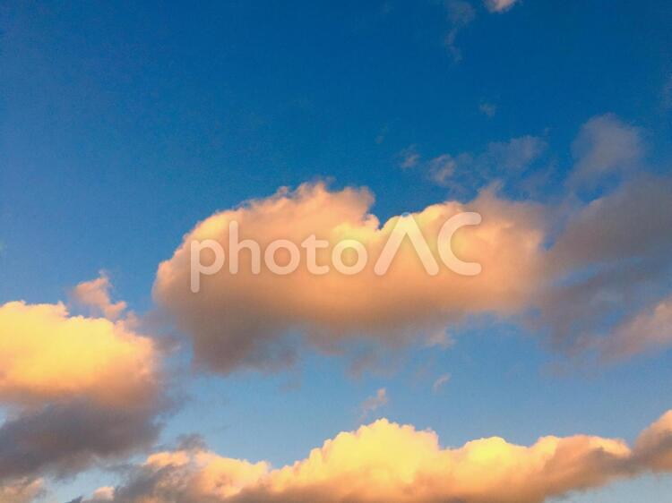 夕陽に照らされオレンジ色になった夕焼け雲 空,青空,晴れの写真素材