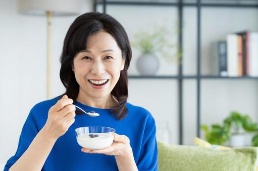 ヨーグルトを食べるミドルの女性 ヨーグルトを食べるミドルの女性の写真
