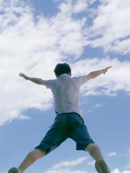 空を仰ぐ少年 前向き,大の字,ジャンプの写真素材