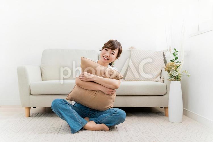家でクッションを持つ笑顔のアジア人女性 女性,笑顔,笑うの写真素材