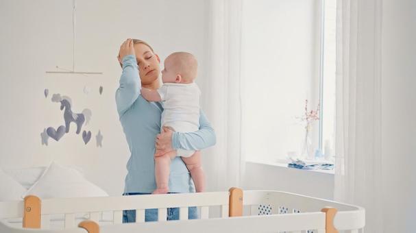 頭痛で赤ちゃんを抱く女性 頭痛で赤ちゃんを抱く女性 女性,赤ちゃん,かわいいの写真素材