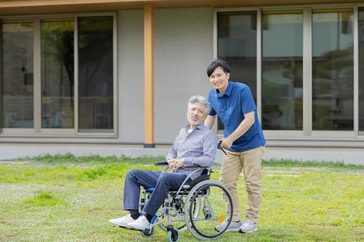 車椅子に乗ったシニア男性と介護士 車椅子に乗ったシニア男性と介護士 シニア,介護,車椅子の写真素材