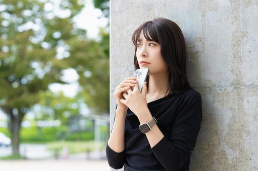 スマホを持って考えごとをする女性 スマホを持って考えごとをする女性 女性,困る,考えるの写真素材