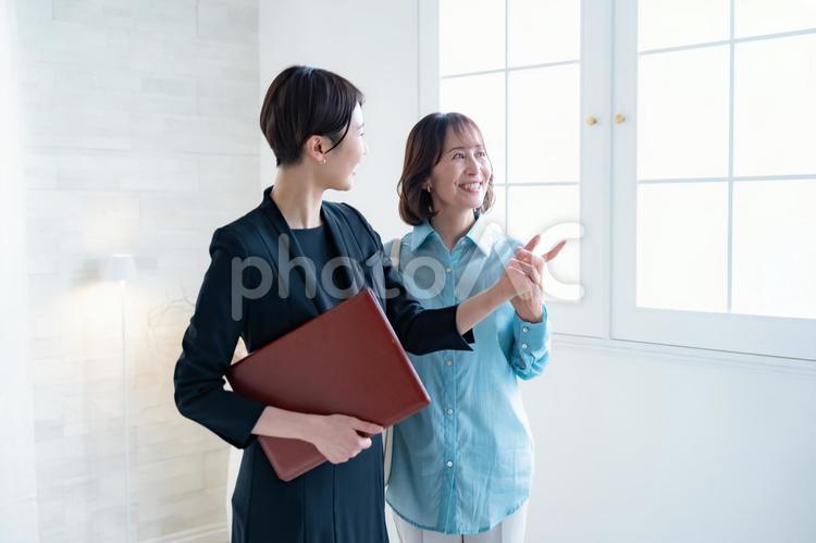 シニア女性とスーツを着た女性 レシェプション,受付,ビジネスウーマンの写真素材