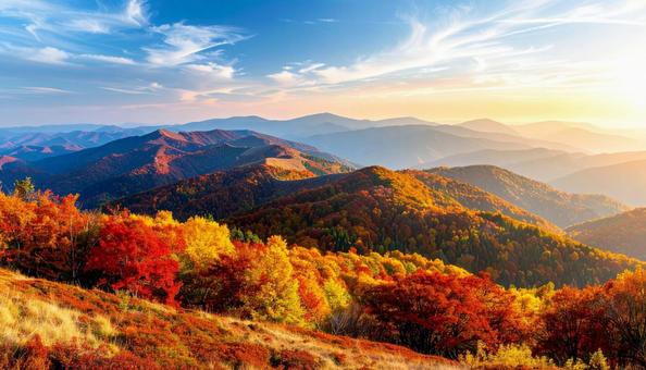 紅葉に包まれた山並みと朝焼けの空 紅葉に包まれた山並みと朝焼けの空の写真