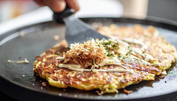お好み焼きを鉄板で焼く お好み焼きを鉄板で焼くの写真