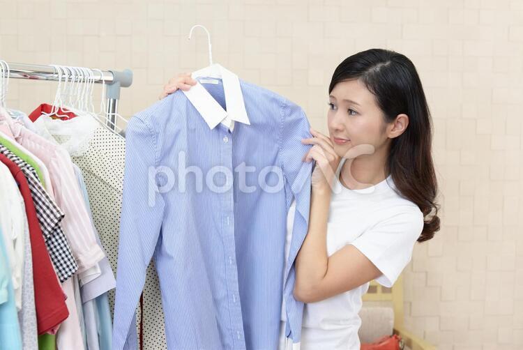 衣類を選ぶ女性 女性,女,笑顔の写真素材