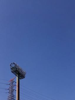 秋晴れ快晴の空にそびえる大型照明と送電塔 空,背景,風景の写真素材