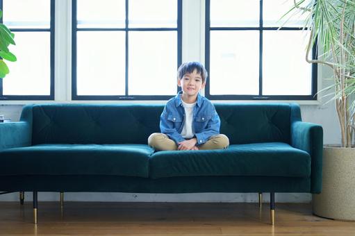 ソファーであぐらでカメラ目線の男の子 ソファーであぐらでカメラ目線の男の子の写真