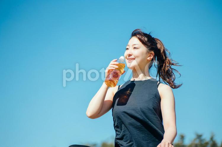 お茶を飲むスポーツウェアの女性 お茶,ドリンク,空の写真素材