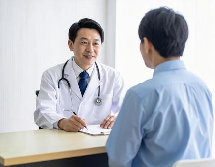白衣を着た医師が患者と相談している様子の写真