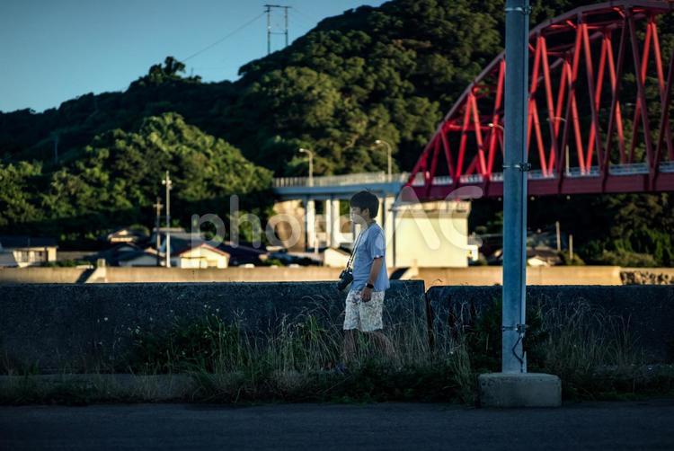 ＜素材＞カメラ片手に観光地を散策する少年 子供,橋,観光地の写真素材