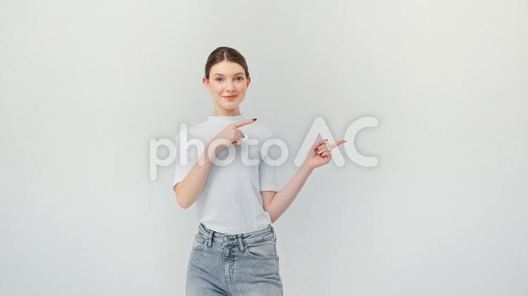 微笑み指差すお団子ヘアの女性 女性,指差し,ジェスチャーの写真素材