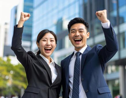 成功を喜ぶ若手社員の笑顔とガッツポーズ 成功を喜ぶ若手社員の笑顔とガッツポーズの写真