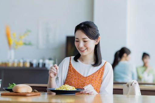 カフェで食事をする若い女性 カフェで食事をする若い女性の写真
