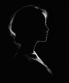 黒背景に浮かぶ女性の横顔シルエット写真 黒背景に浮かぶ女性の横顔シルエット写真の写真