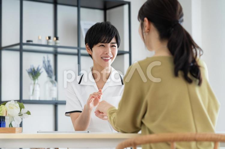 若い女性の接客をするサロンのスタッフ エステサロン,受付,カウンセリングの写真素材
