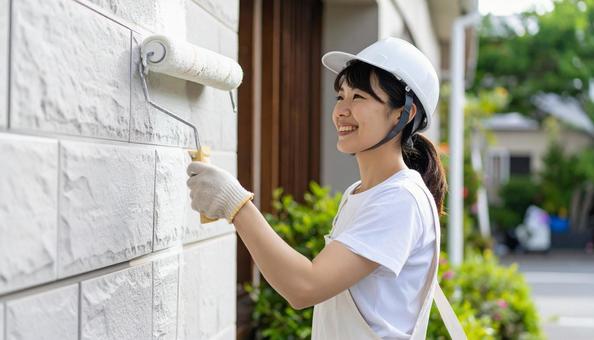 DIYで外壁塗装する女性 DIYで外壁塗装する女性の写真