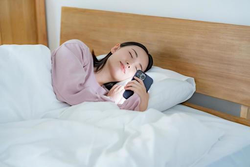 寝落ちする女性 寝落ち,携帯電話,トラブルの写真素材