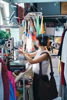 店頭でカセットテープを手に取る若い女性 カセット,サブカル,カセットテープの写真素材