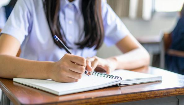 ノートに記入する日本人中学生の女の子の手 ノートに記入する日本人中学生の女の子の手の写真