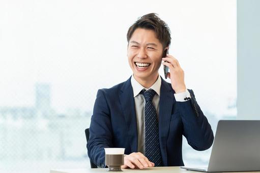 スマホで通話をする笑顔の男性ビジネスマン スマホで通話をする笑顔の男性ビジネスマン 男性,スマホ,スマートフォンの写真素材