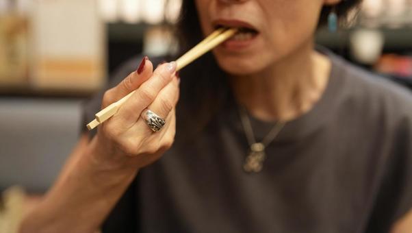 箸を口に運ぶ女性 箸を口に運ぶ女性 女性,食事中,箸の写真素材