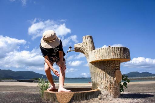 <素材>夏の海水浴場で足を洗う男の子 <素材>夏の海水浴場で足を洗う男の子 子供,小学生,夏の写真素材