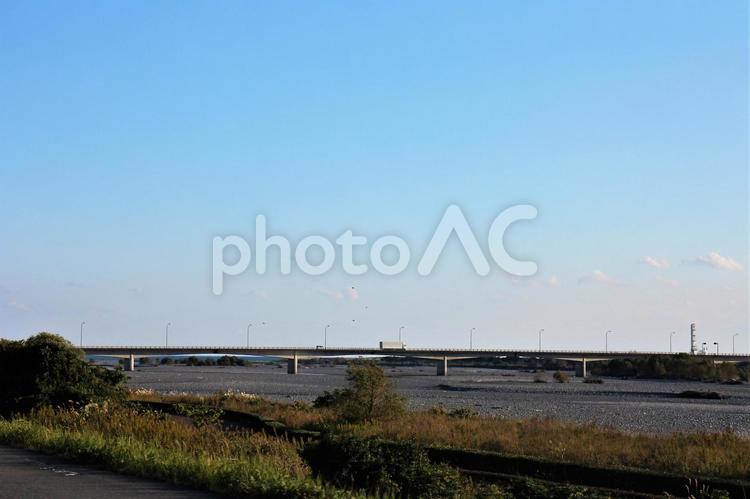 秋の大井川の橋を通るトラックと橋の下に覗く水平線 川,水平線,海の写真素材
