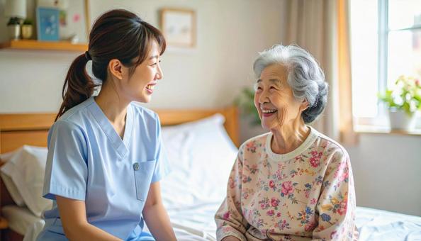笑顔で話をする女性介護士と高齢女性の写真
