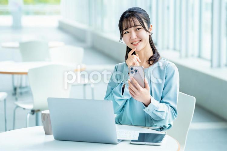 スマホを見て考えごとをする女性 女性,スマホ,スマートフォンの写真素材