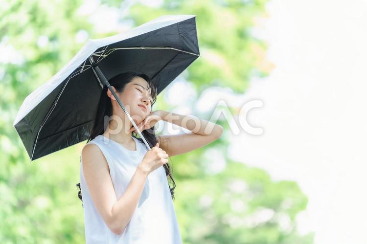 日傘をさすアジア人女性（体調不良・汗） 日傘,熱中症,暑いの写真素材