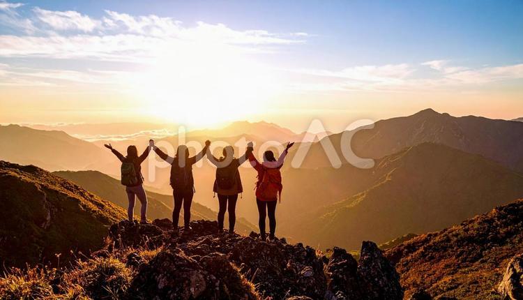 夏山で朝日に向かって手をあげる登山者 夏山,朝日,登山者の写真素材