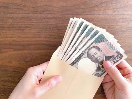 机上で茶封筒に入った紙幣を持つ女性の手 お金,持つ,手の写真素材