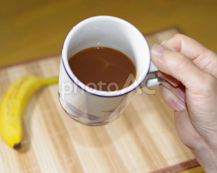 コーヒーを飲もうとしている人 コーヒー,朝食,バナナの写真素材