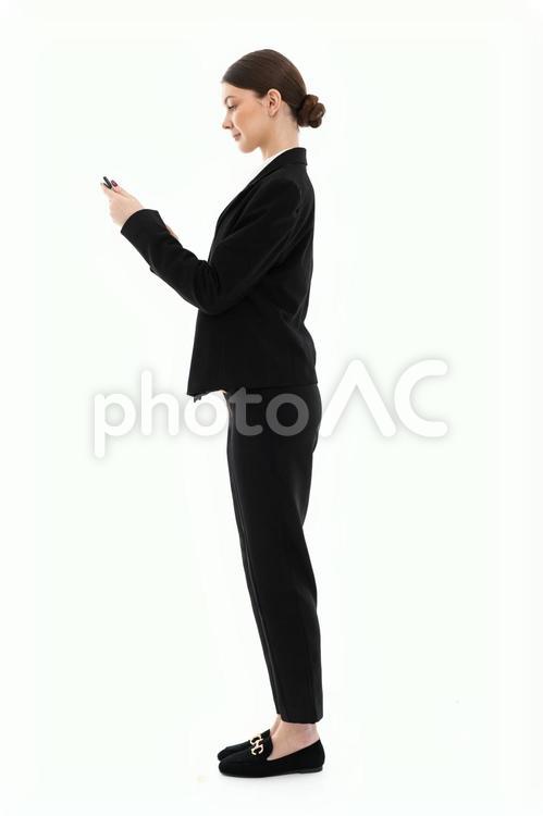 スマホを見る横向きのスーツ女性 女性,スマートフォン,持つの写真素材