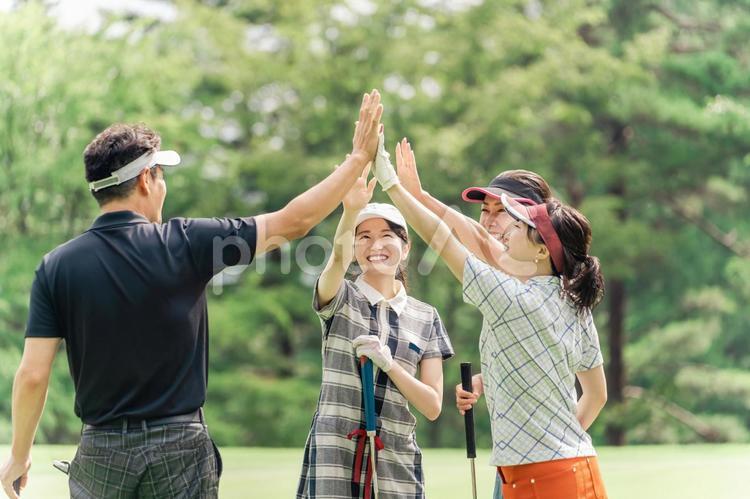 ゴルフ場でハイタッチするゴルフ仲間の男女 ゴルフ,ゴルフ場,ゴルフクラブの写真素材