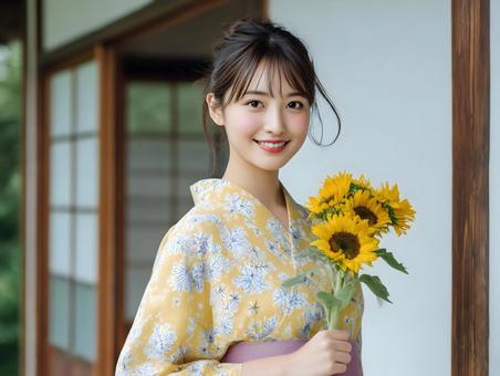 ひまわりを手に持つ浴衣を着た笑顔の女性 ひまわりを手に持つ浴衣を着た笑顔の女性の写真